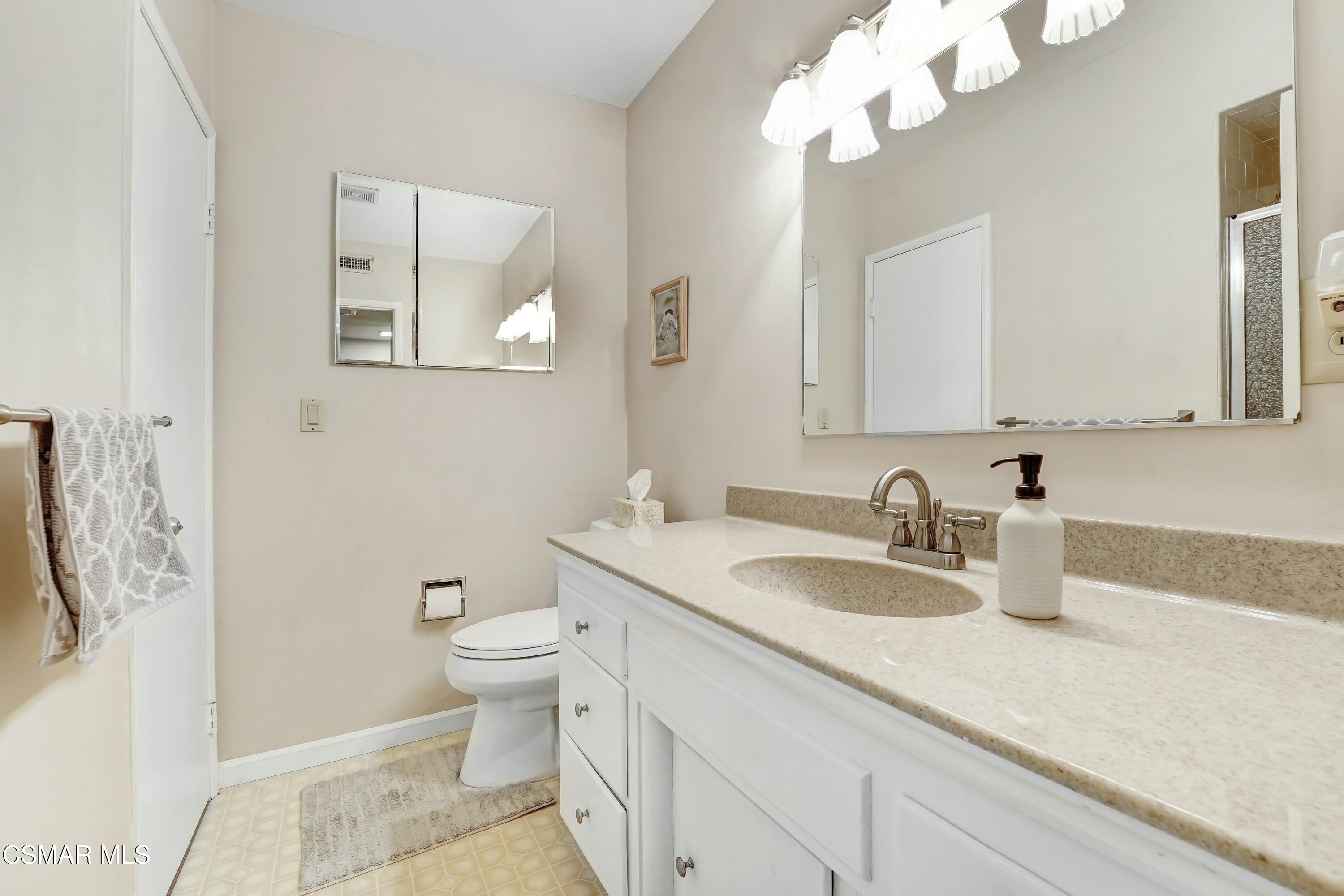 3075 Reservoir Drive Simi Valley, CA 93065 - Photo 8 of 20 a bathroom with a sink a toilet and a mirror