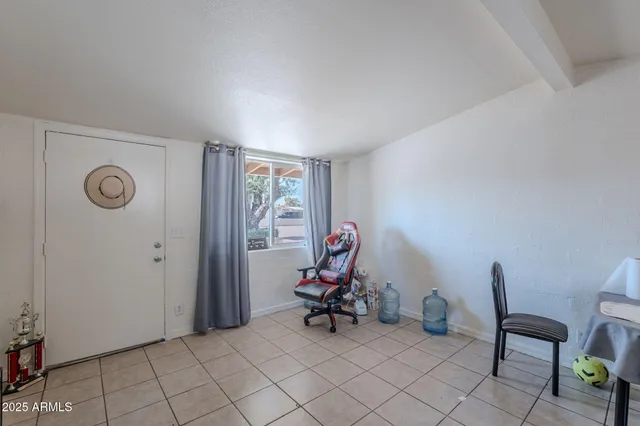 a view of a workspace with furniture and a window