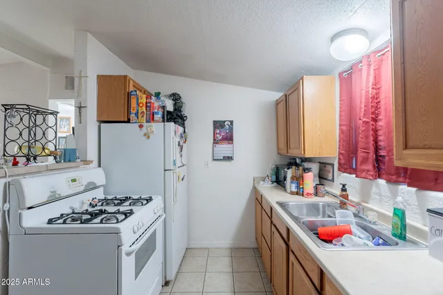 a kitchen with a refrigerator and a stove top oven