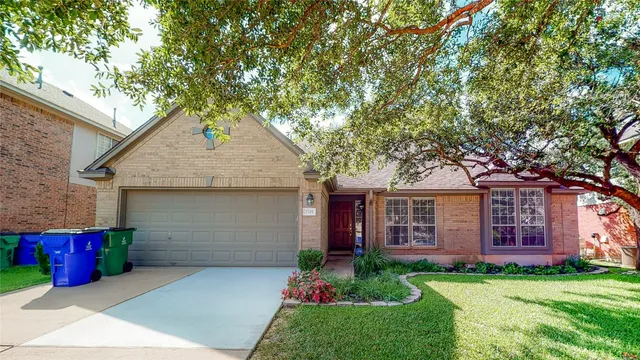 a front view of a house with a garden and yard