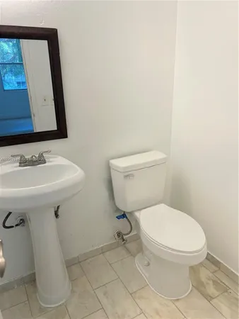 a white toilet sitting next to a bathroom sink
