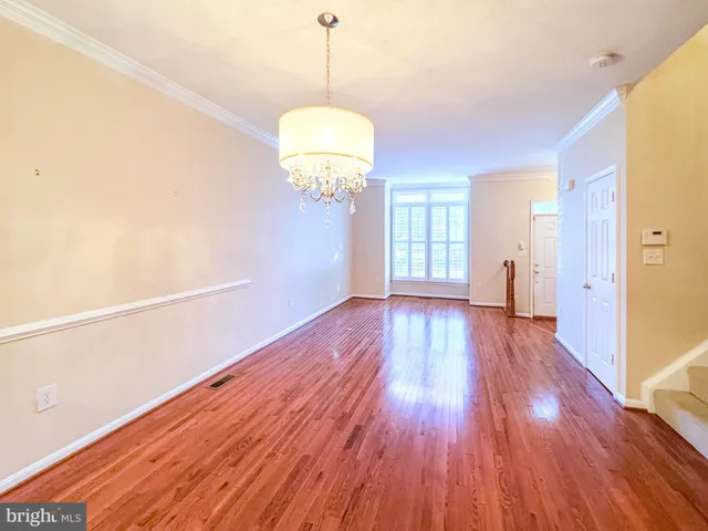 a view of a room with wooden floor and chandelier