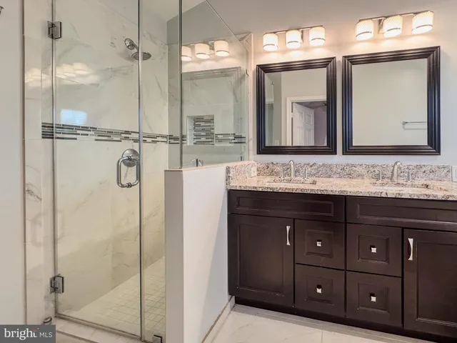 a bathroom with a shower sink vanity and mirror