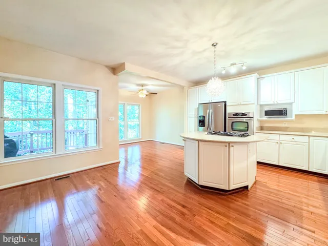 a kitchen with wooden floors and white cabinets