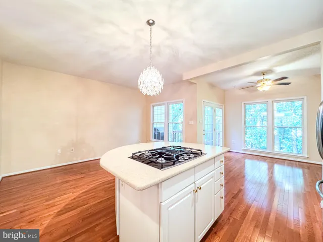 a kitchen that has a lot of cabinets a stove and a wooden floors