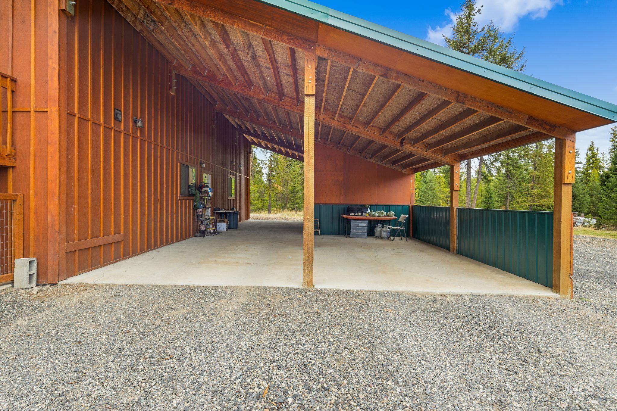 3989 East Mountain Road Anatone, WA 99401 - Photo 38 of 49 Covered patio with a concrete slab, exposed wood beam ceiling, and wood-finish siding