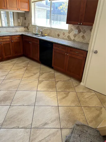 a kitchen with stainless steel appliances a sink cabinets and window
