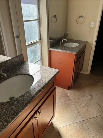 a bathroom with a granite countertop sink a mirror and a bathtub