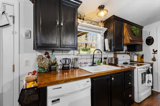 a kitchen with stainless steel appliances granite countertop a sink stove and cabinets