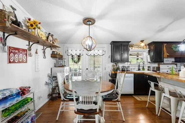 a dining room filled chandelier and wooden floor