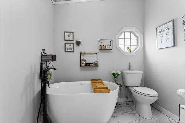 a white toilet sitting next to a bathroom sink and tub