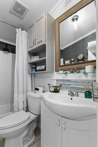 a bathroom with a sink a toilet and a mirror