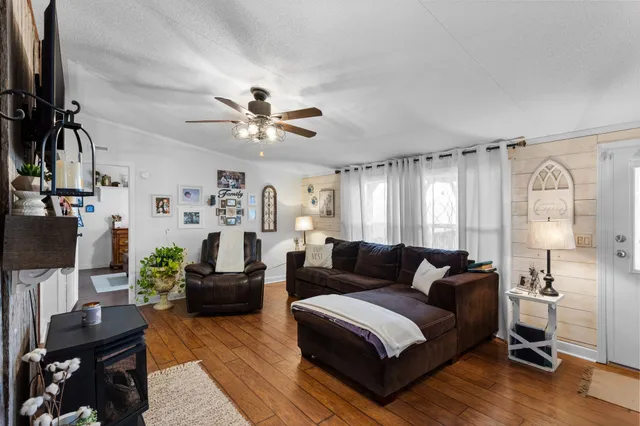 a living room with furniture and a flat screen tv with wooden floor