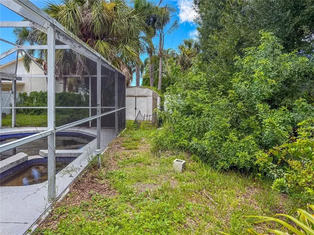a view of a backyard with potted plants and large tree