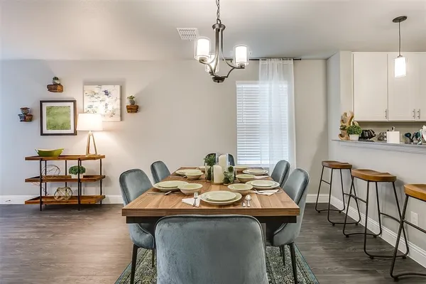 a view of a dining room with furniture a chandelier and wooden floor
