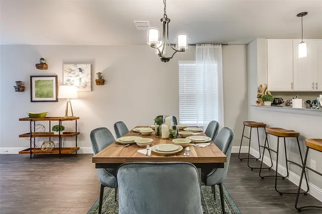 a view of a dining room with furniture a chandelier and wooden floor