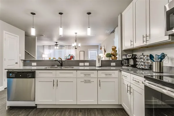 a kitchen with white cabinets and white appliances