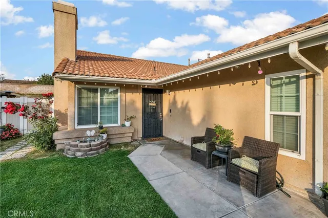 a patio with a table and chairs and potted plants