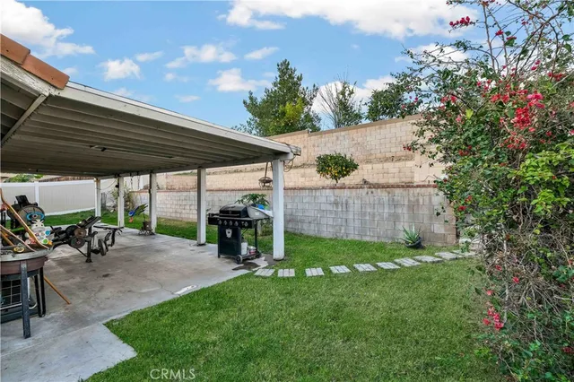 a view of a patio with table and chairs under an umbrella with a tree