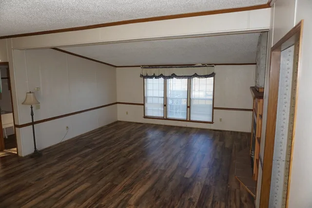 a view of empty room with wooden floor and fireplace