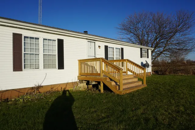 a view of a house with backyard and sitting area