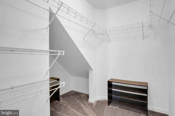 a view of walk in closet with empty racks