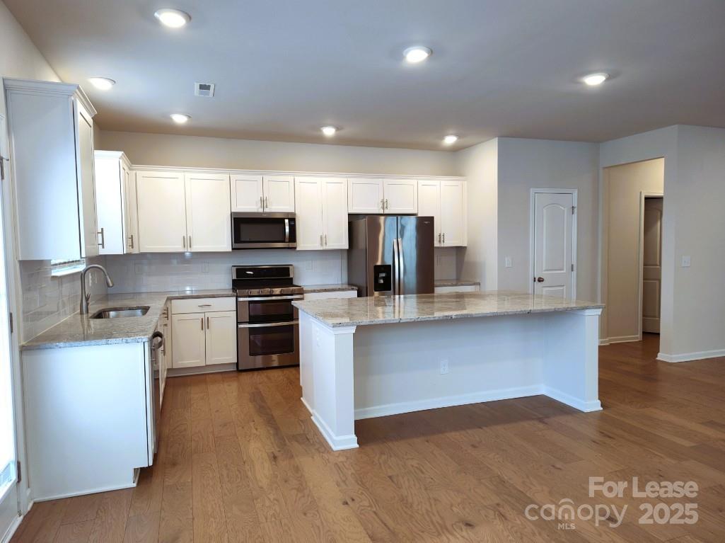 3327 Glenn Hope Way Matthews, NC 28104 - Photo 4 of 23 a kitchen with stainless steel appliances granite countertop a stove a sink and a refrigerator