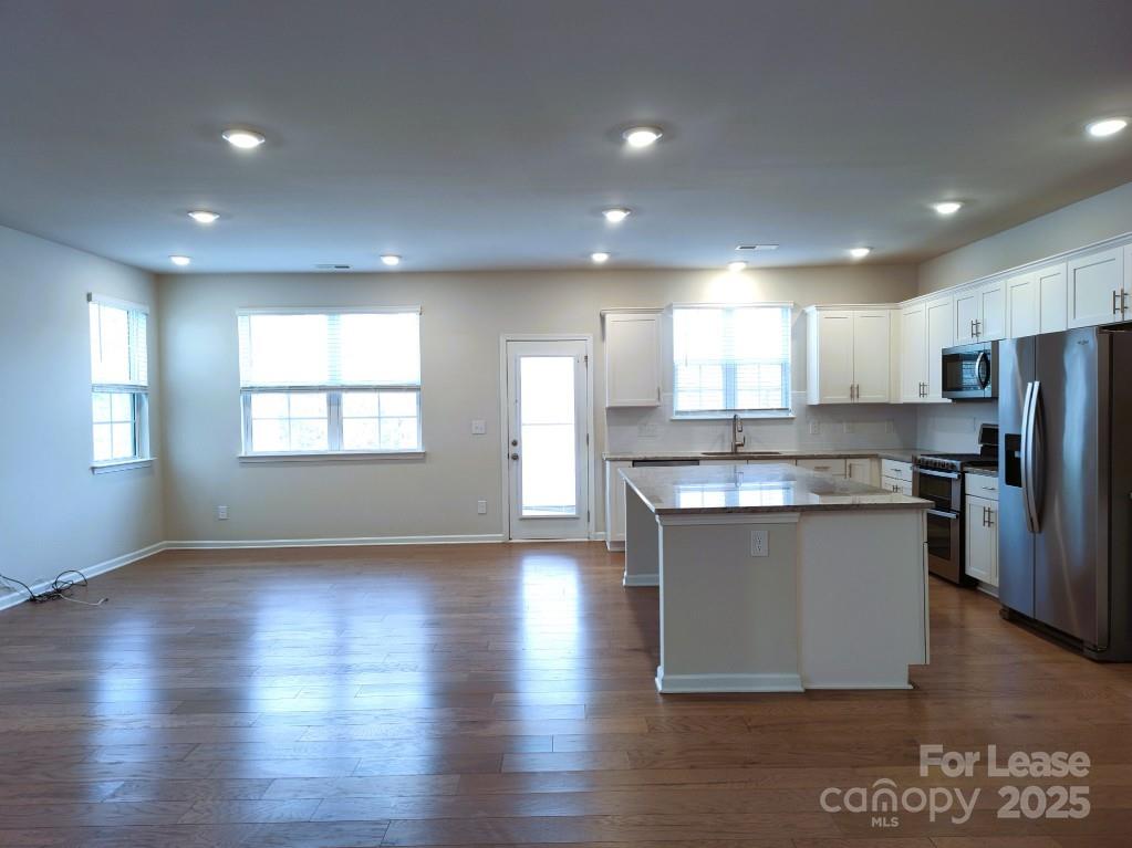 3327 Glenn Hope Way Matthews, NC 28104 - Photo 5 of 23 a kitchen with stainless steel appliances granite countertop a refrigerator a sink dishwasher a stove and a microwave oven on the wooden floor