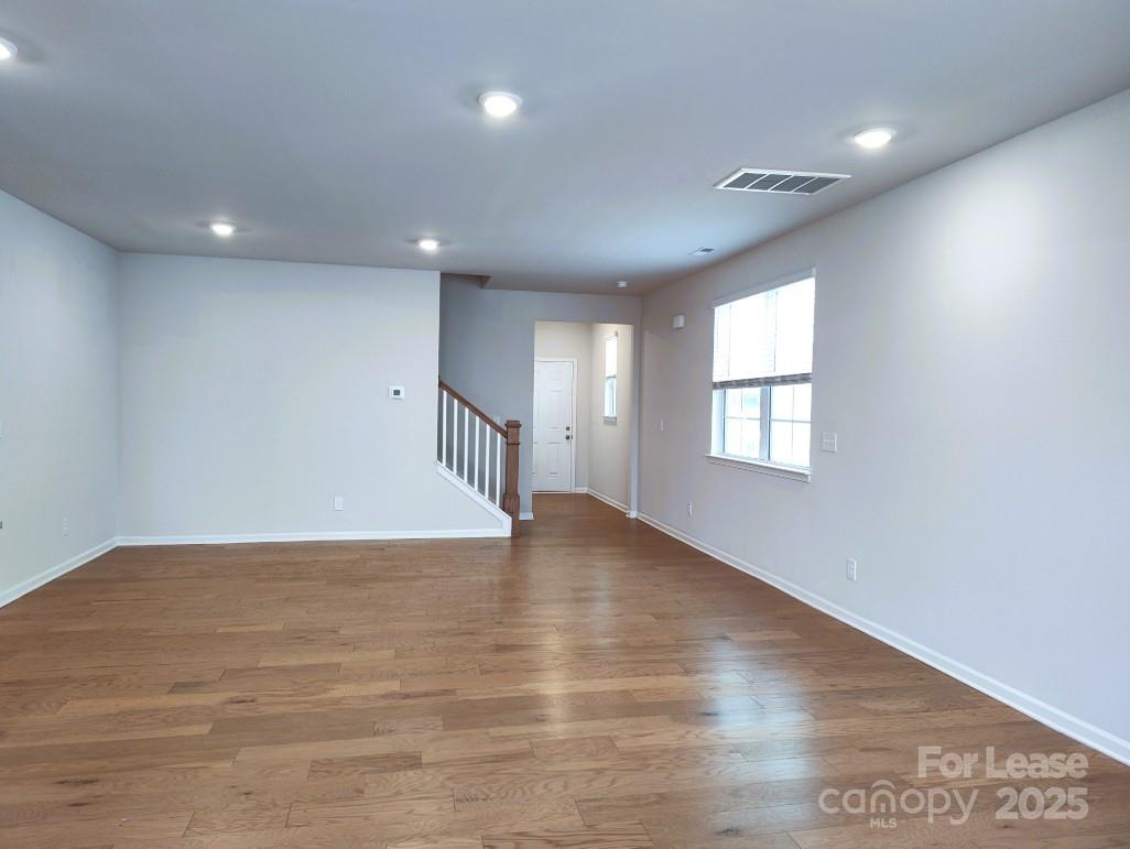 3327 Glenn Hope Way Matthews, NC 28104 - Photo 8 of 23 an empty room with wooden floor and windows
