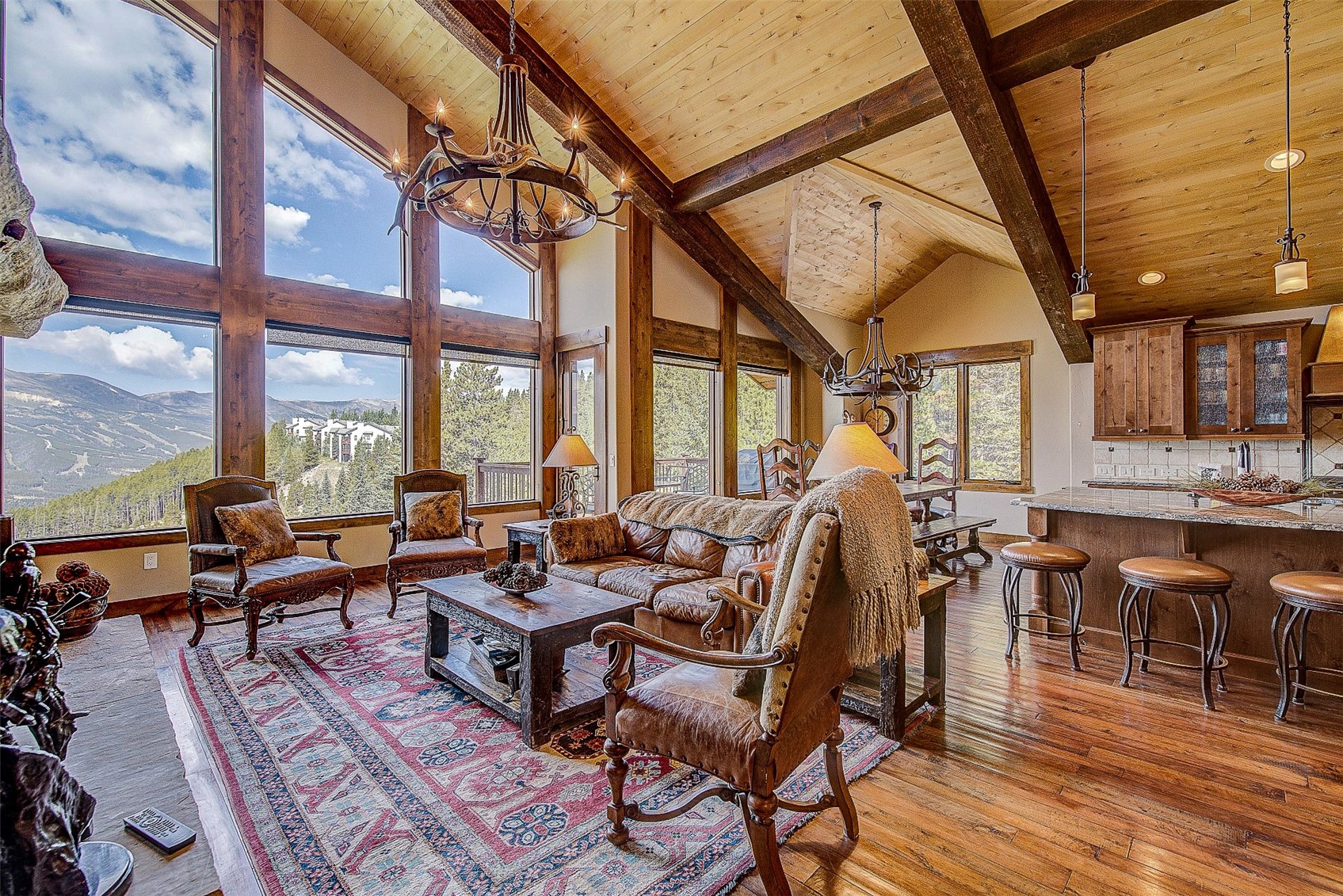 59 Club House Road, Unit C Breckenridge, CO 80424 - Photo 19 of 50 Living area with a chandelier, light wood-style flooring, high vaulted ceiling, a wooden ceiling with exposed beams, and a mountain view