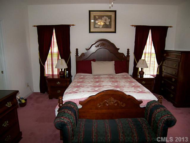 5711 Griffith Road Monroe, NC 28112 - Photo 14 of 16 a bedroom with a bed and a painting on the wall