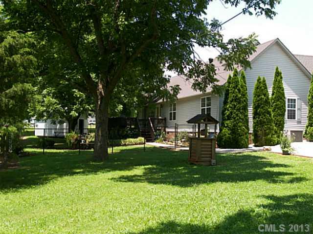 5711 Griffith Road Monroe, NC 28112 - Photo 4 of 16 a front view of a house with a garden and trees