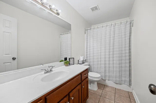 a bathroom with a sink a toilet and shower curtain