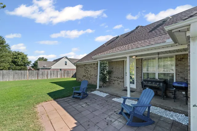 a view of a house with backyard sitting area and garden
