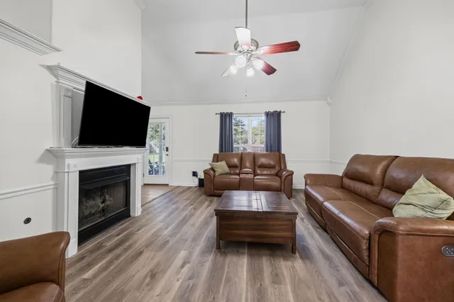 a living room with furniture a flat screen tv and a fireplace