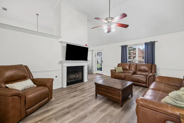 a living room with furniture a fireplace and a flat screen tv