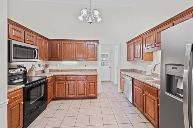 a kitchen with stainless steel appliances granite countertop a stove top oven a sink dishwasher and a microwave oven on the blue kitchen countertops