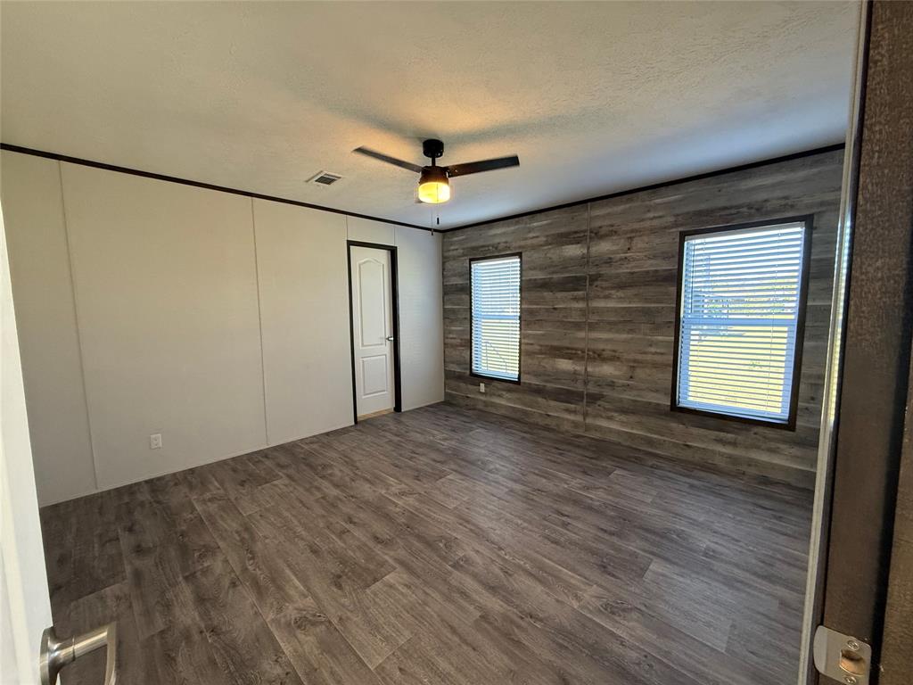 439 Whitefoot Quitman, TX 75783 - Photo 13 of 35 a view of empty room with wooden floor and fan