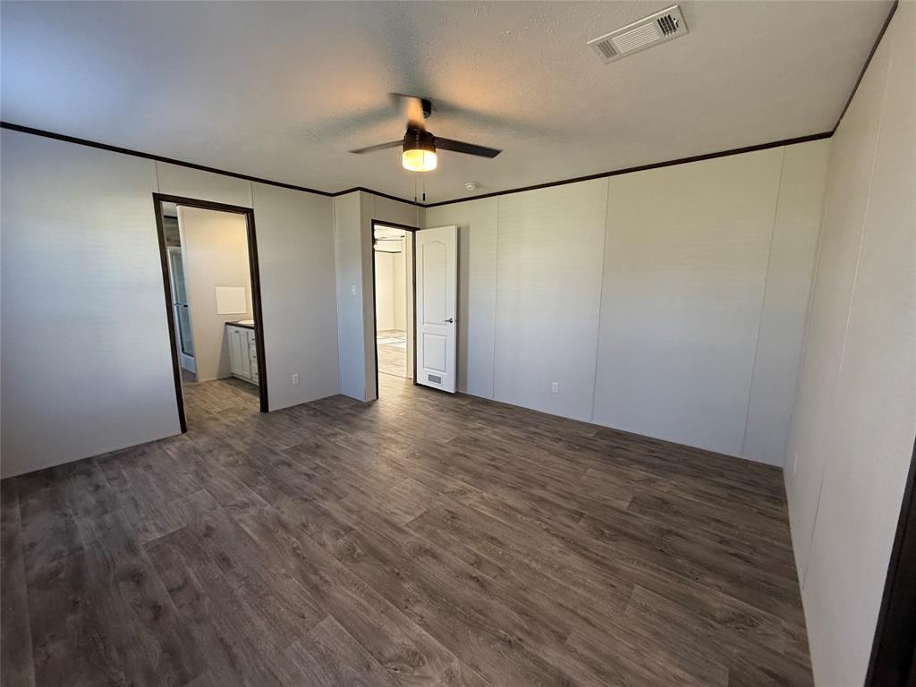 439 Whitefoot Quitman, TX 75783 - Photo 15 of 35 an empty room with wooden floor chandelier and windows