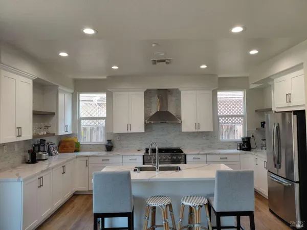 a kitchen that has a refrigerator a table and chairs in it