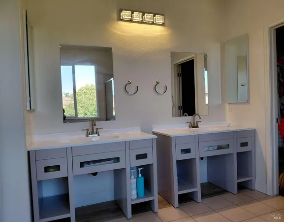 a bathroom with a granite countertop sink double and mirror