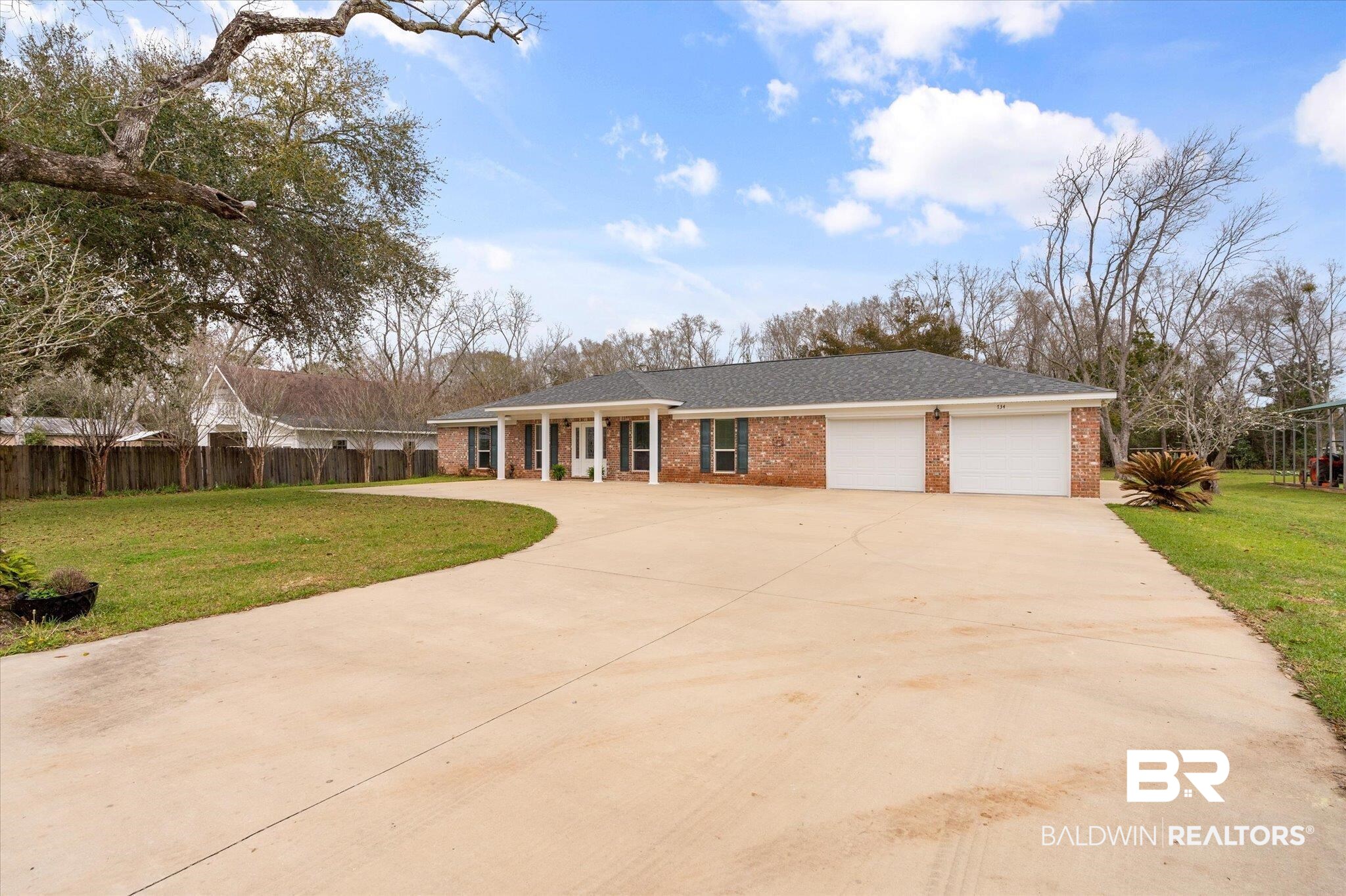 734 West Section Avenue Foley, AL 36535 - Photo 48 of 50 View of front of house with a front lawn, driveway, fence, a garage, and brick siding
