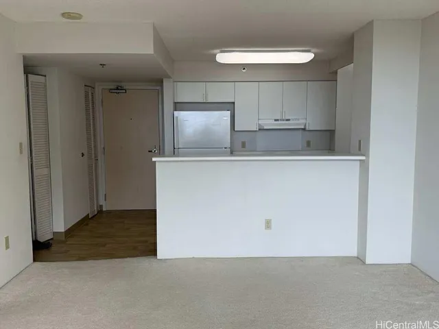 an empty room with mirror and cabinets