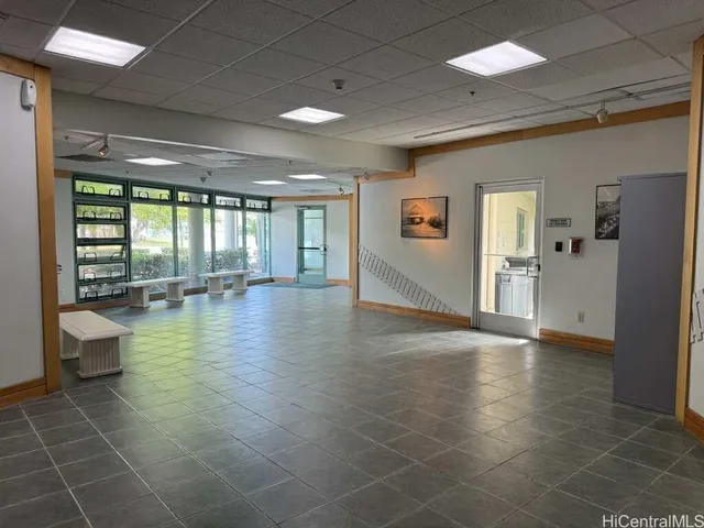a view of a hallway with wooden floor and a bathroom
