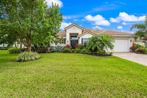 a view of a house with a yard and potted plants