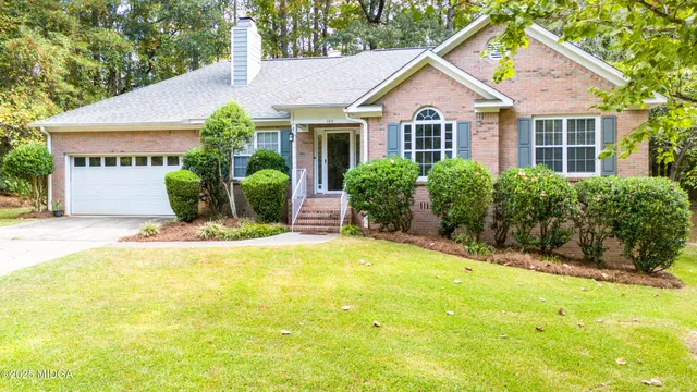 a front view of a house with a yard and potted plants