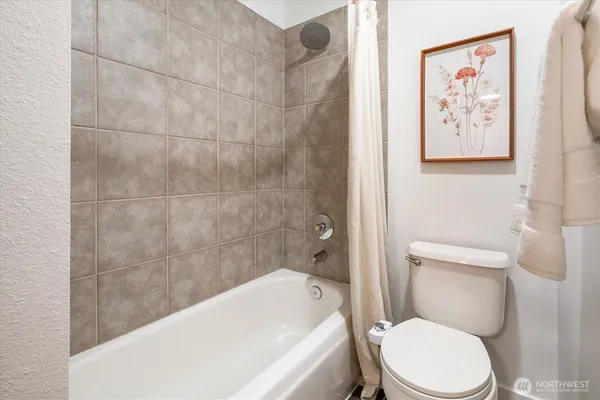 a white toilet sitting next to a bathtub