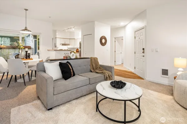 a living room with furniture a dining table and a chandelier