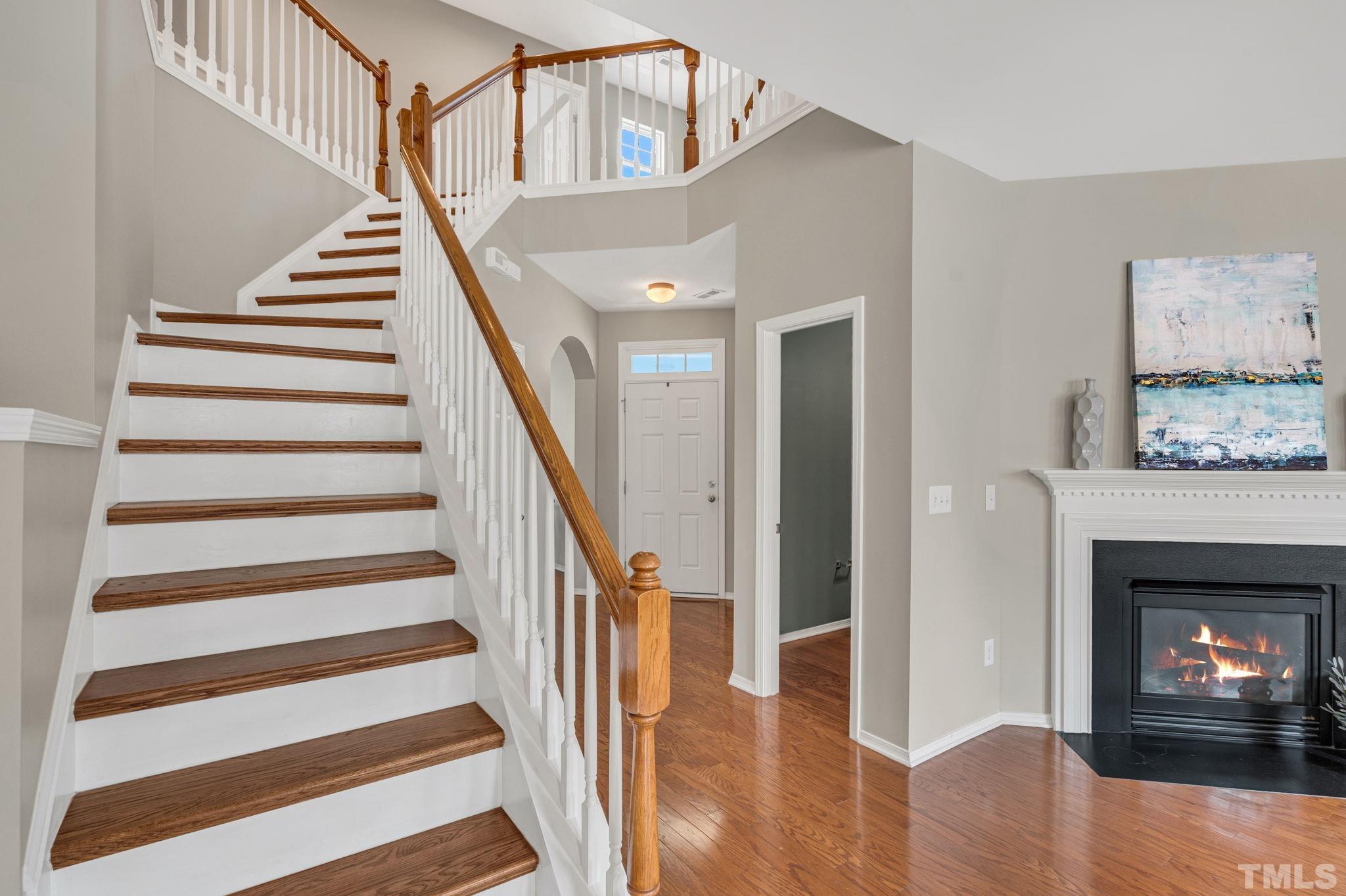 8215 Beaded Stone Street Raleigh, NC 27613 - Photo 16 of 41 a view of an entryway with wooden floor and a fire place