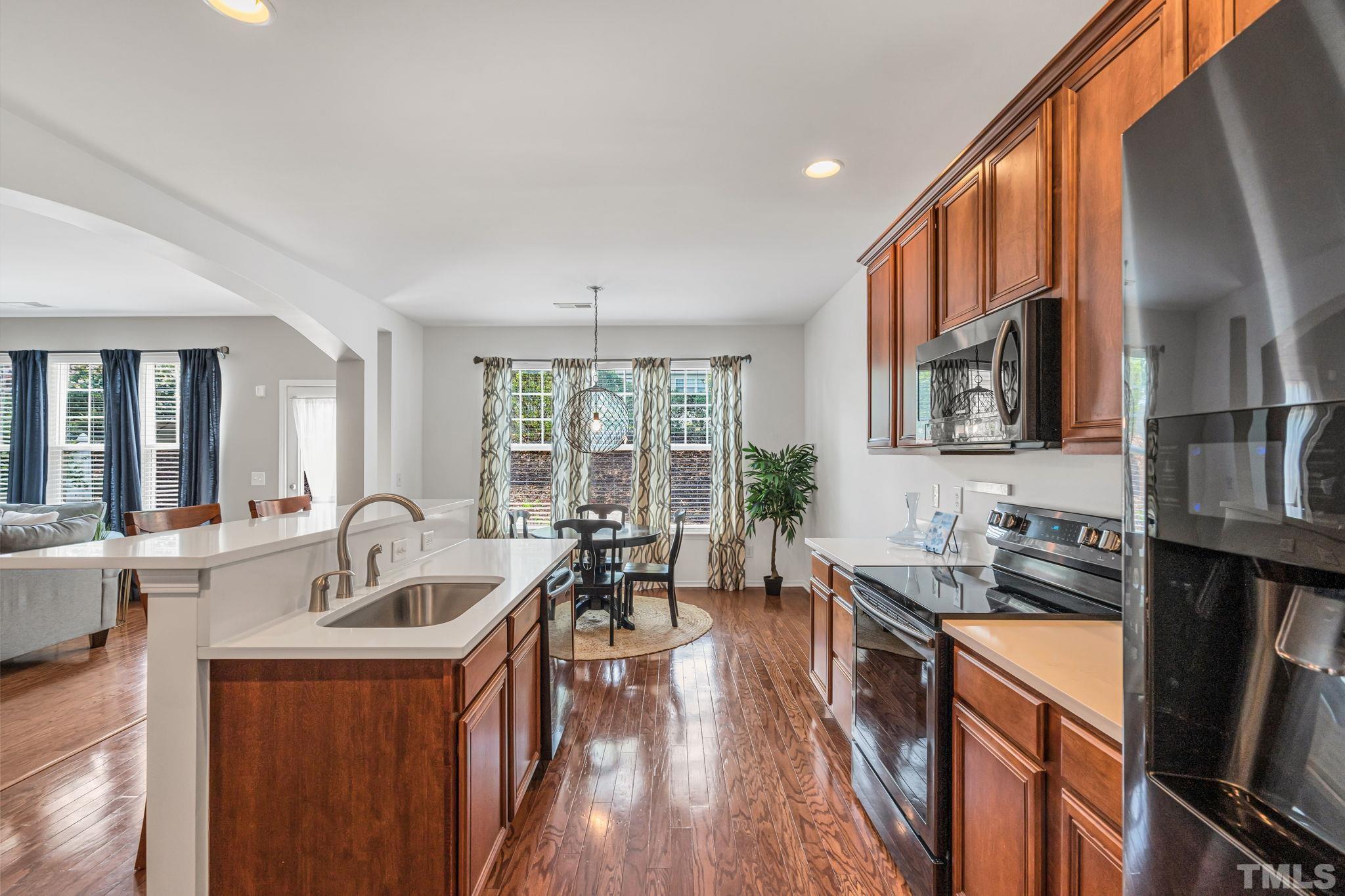 8215 Beaded Stone Street Raleigh, NC 27613 - Photo 8 of 41 a kitchen with sink refrigerator and large window
